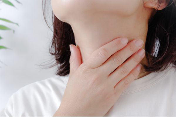 喉をおさえる手